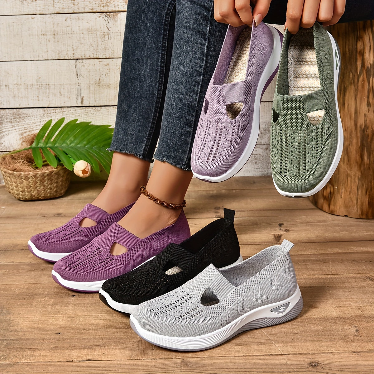 Four pairs of casual shoes in purple, black, gray, and green on a wooden floor.